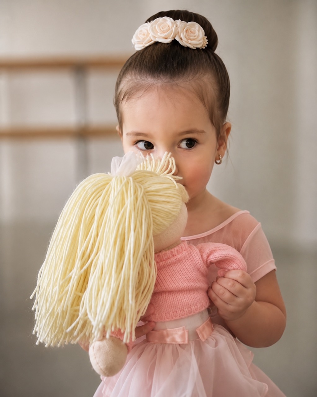 Young ballet student holding a doll in class