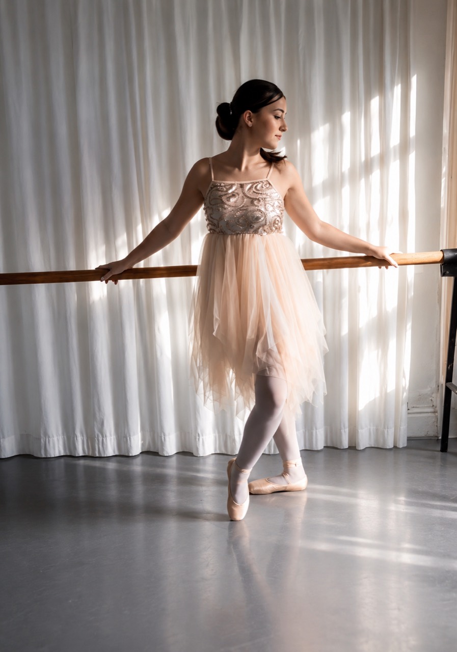 Ballet dancer at the barre in soft studio light