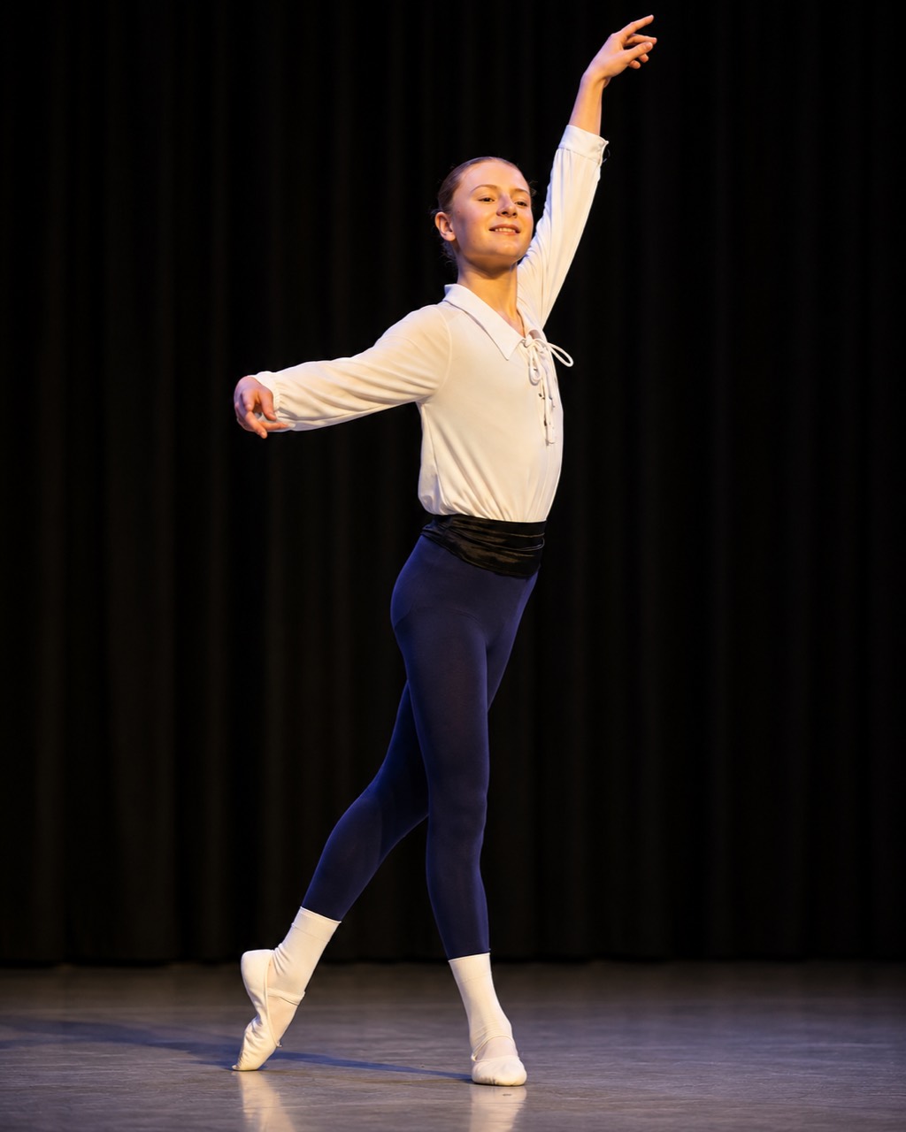 Young male ballet dancer performing on stage